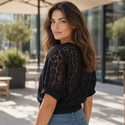Mujer vistiendo blusa negra calada Desigual con mangas murciélago y diseño floral, disponible en liquidationlive