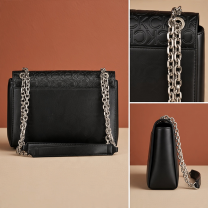 Bolso negro Calvin Klein de liquidationlive con solapa texturizada, iniciales en relieve y asas de cadena plateada.