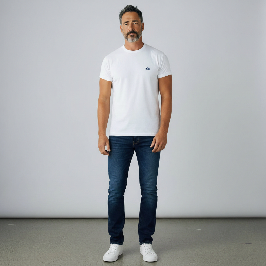 Hombre con camiseta blanca La Martina de cuello redondo y logo bordado, combinada con vaqueros oscuros