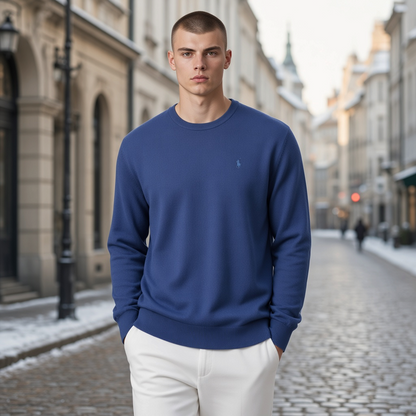 Jersey azul de cuello redondo La Martina con bordado discreto para hombre, combinado con pantalones claros en la calle.