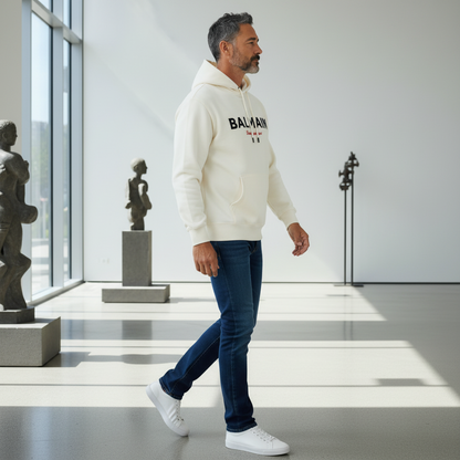 Hombre caminando con sudadera con capucha color crema de liquidationlive, jeans oscuros y zapatillas blancas.