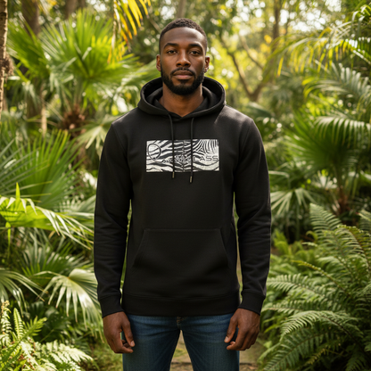 Hombre con sudadera negra con capucha Cavalli Class y logo estampado en un entorno de selva tropical